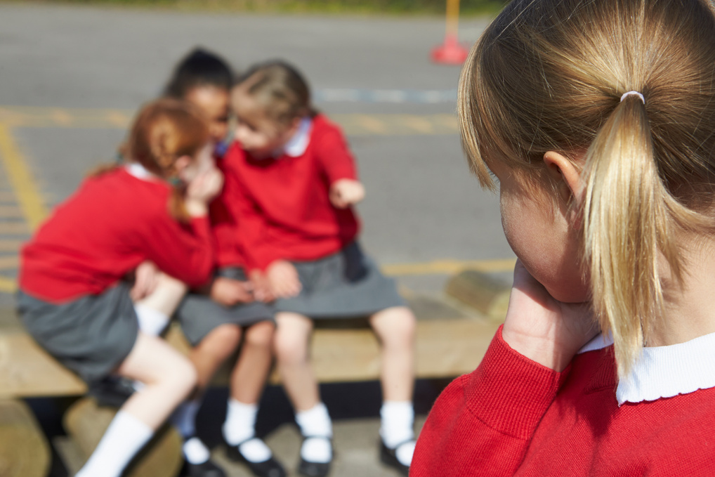 Female Elementary School Pupils Whispering in Playground